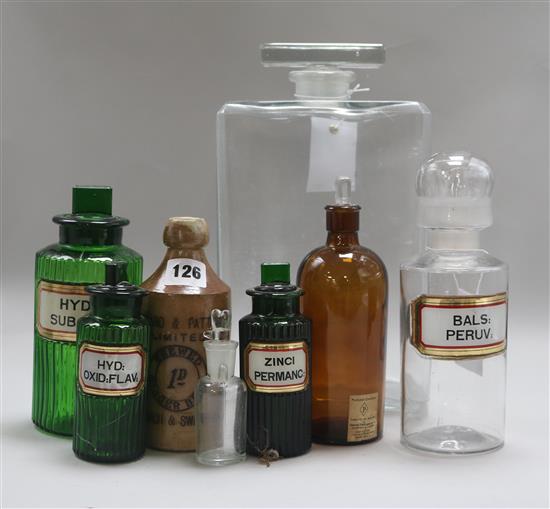 A large glass display scent bottle and six pharmacy glass jars and a stoneware bottle